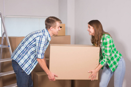 快乐的年轻夫妇开箱或填料盒和搬入新屋