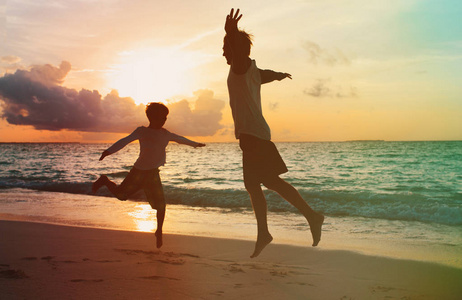 父子玩耍, 玩得开心, 在日落海滩跳