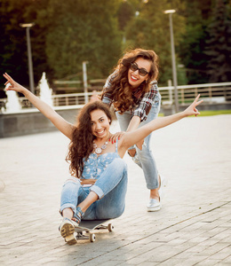 两个年轻女孩在户外玩滑板的乐趣