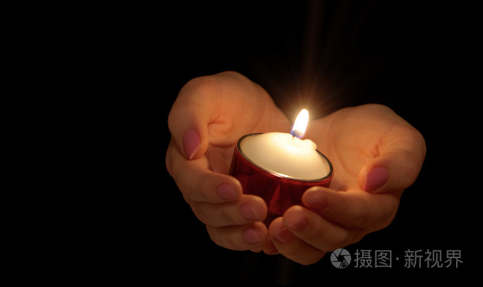 在女性手中燃烧蜡烛