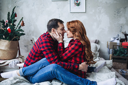 幸福的未来父母在对衣裳等待婴孩, 已婚夫妇是等待孩子, 怀孕妇女用红色长的头发, 怀孕的秀丽, 家庭夫妇是拥抱在卧室