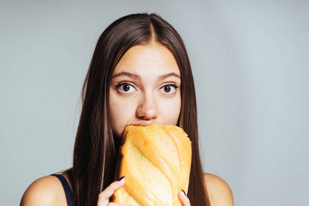 一个饥饿的女孩是在节食，急切地吃有害的白面包