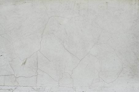 纹理的灰色的水泥墙上的裂缝和孔洞