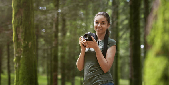 摄影师在森林里拍照图片