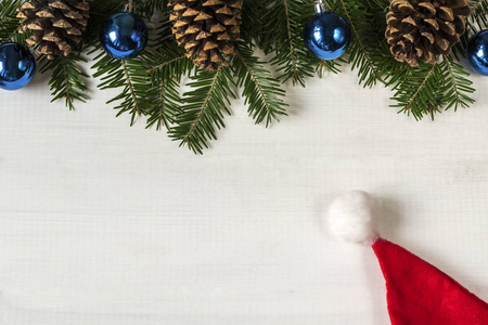 白色木制背景下的圣诞装饰与圣诞老人帽子