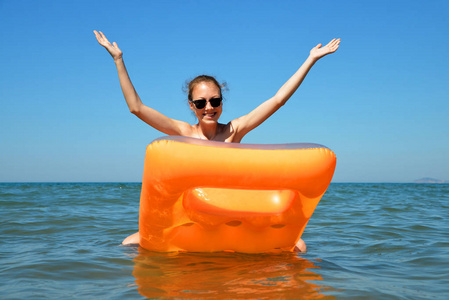 年轻的女孩，漂浮在海上的充气床垫上。暑假