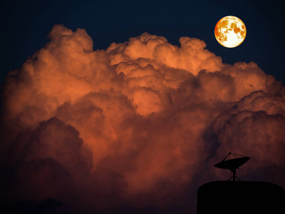 超级血月亮和 sattlelite 磁盘上暗橙色堆云