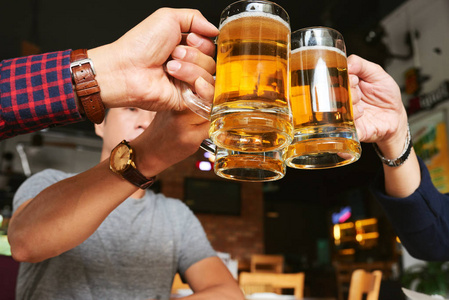 快乐男性朋友在酒吧喝啤酒的亲密形象