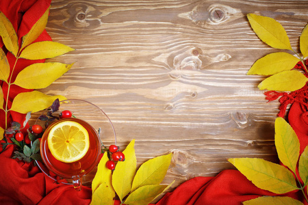 桌上，装饰着秋天的落叶 浆果和新鲜的茶。秋天。秋天的背景