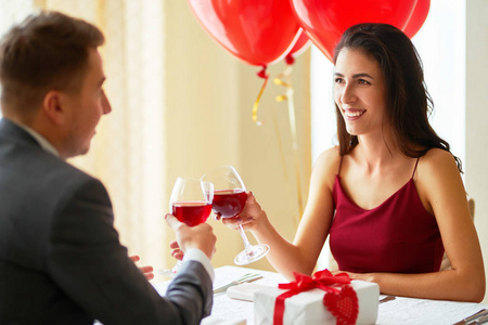 情人节的概念。一对相爱的情侣在餐馆里庆祝情人节。情侣互赠礼物