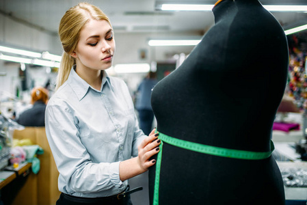 服装设计师测量人体模型, 在缝纫厂制造。服装测量缝纫裁缝