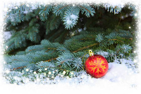 红色的圣诞球的枞树枝上覆盖着雪