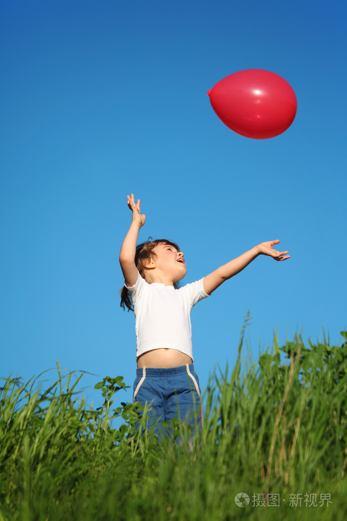 小女孩在草地上玩红色气球