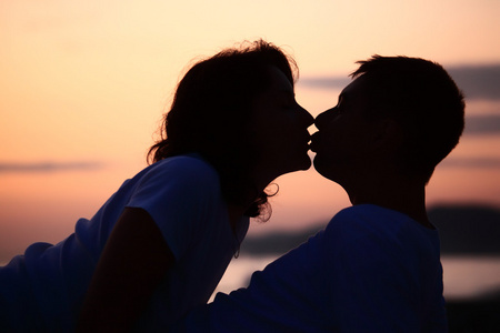 在海滩上亲吻男人和女人的剪影