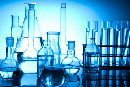 实验室玻璃器皿实验室玻璃器皿用化学物质和书橙色背景微生物学仪器