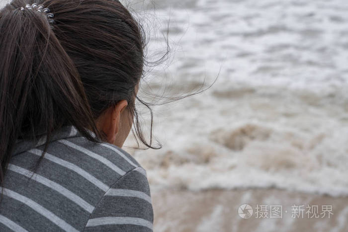 视野中的年轻女子凝视我们的海浪在海滩