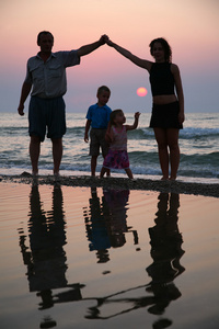 母亲带着孩子和祖父在日落时上岸