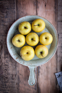 在一个木制背景上的盘子里有水滴的新鲜苹果