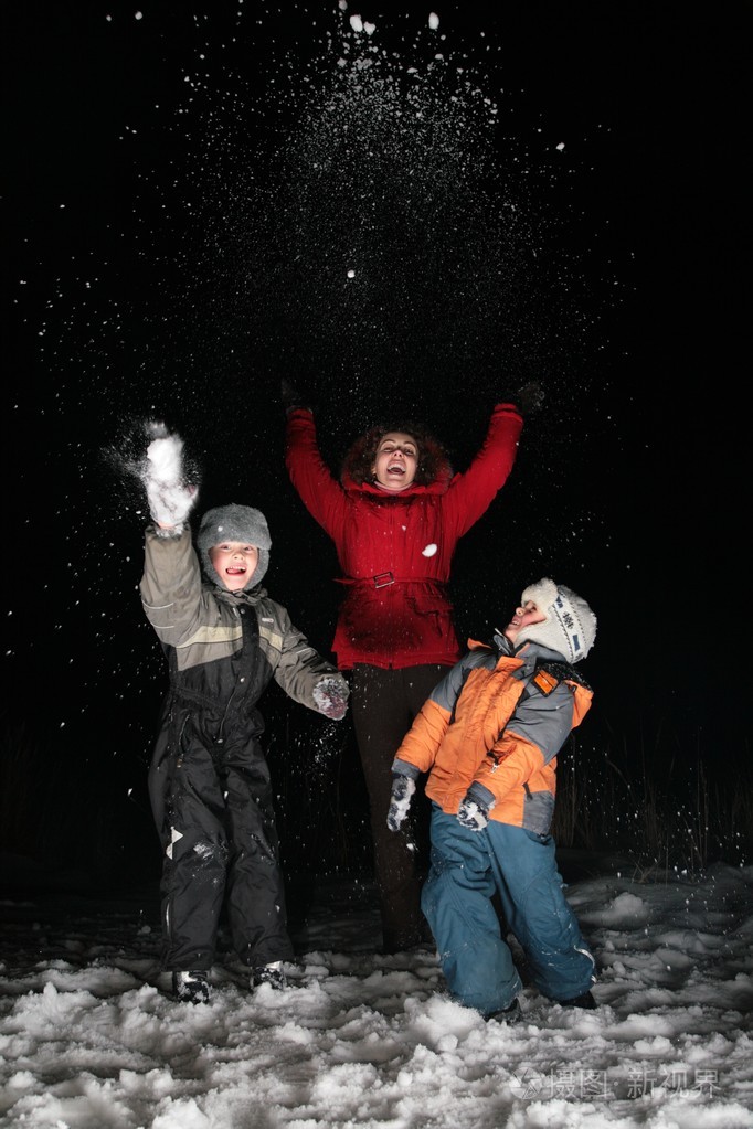 孩子们和妈妈在夜里下雪