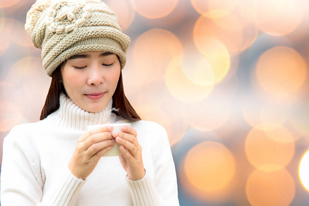 冬天, 女人手捧着一杯白咖啡。在阳光明媚的日子, 美丽的冬天修指甲。博克背景。生活方式概念