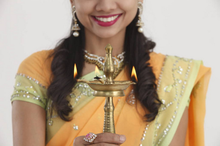 美丽的年轻印度妇女在传统的纱丽礼服举行排灯节油灯灯, 孤立的白色背景