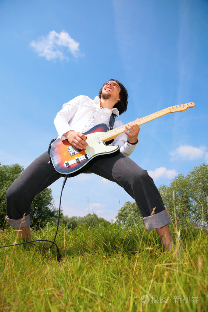 年轻人在草地上弹吉他