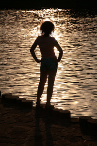 日落时近水的女性剪影