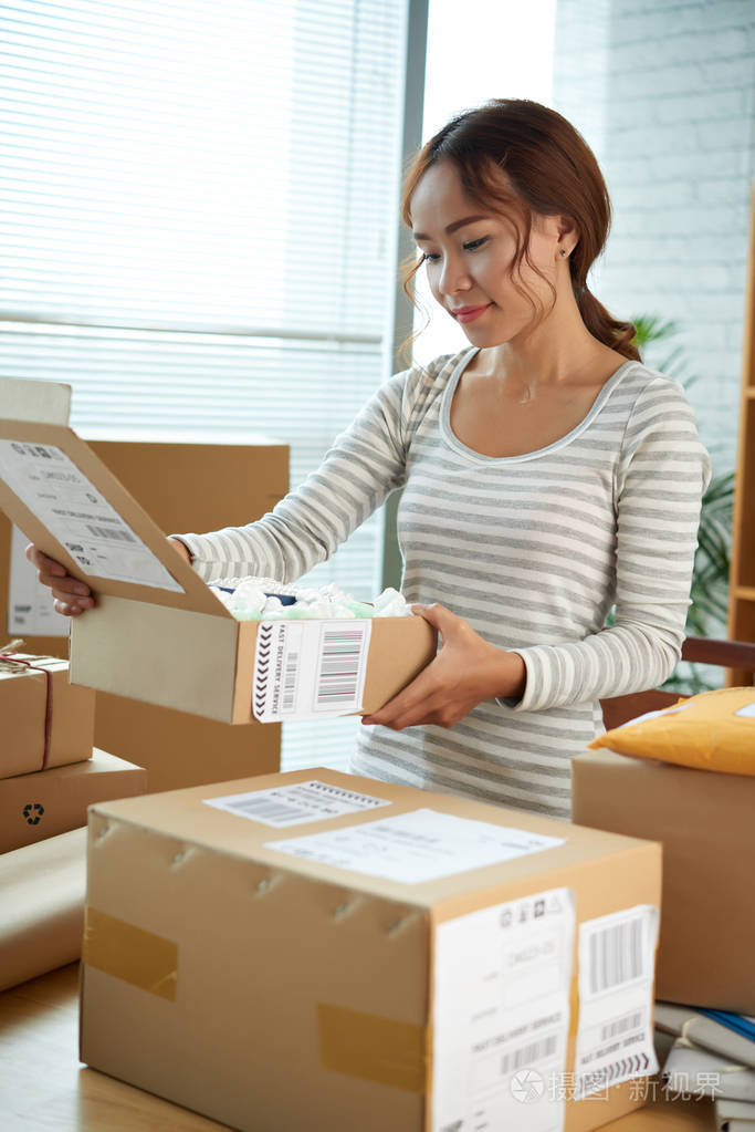 漂亮的亚洲女孩打开许多包裹她收到