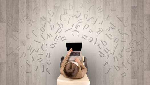 字母与女人在一张椅子上使用笔记本电脑