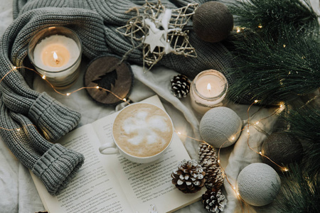 咖啡杯, 书, 圣诞装饰品和保暖针织毛衣。温馨冬日假期