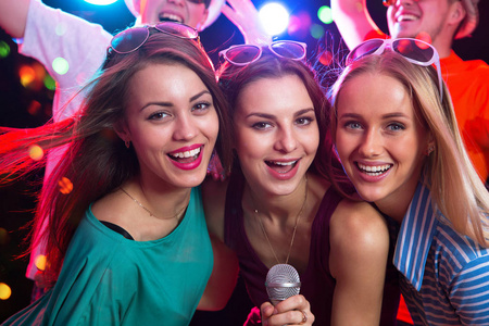 唱歌的乐趣快乐的女孩在聚会上唱歌的乐趣照片