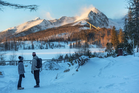 无名的人站在宿萨格勒布的湖边, 望着远处白雪皑皑的山峰, 高高的 Tatras