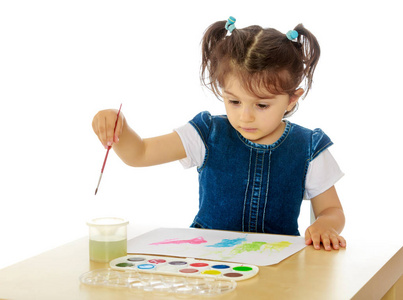 小女孩涂料用水彩在桌
