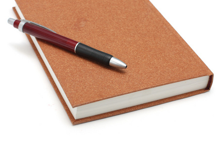 棕色日记本，白色表面，用钢笔