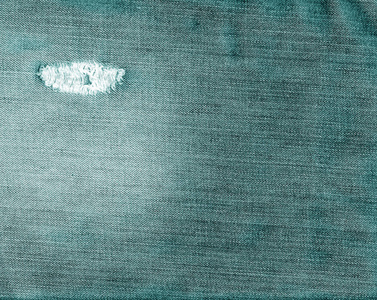 青色颜色撕裂牛仔裤纺织质感照片