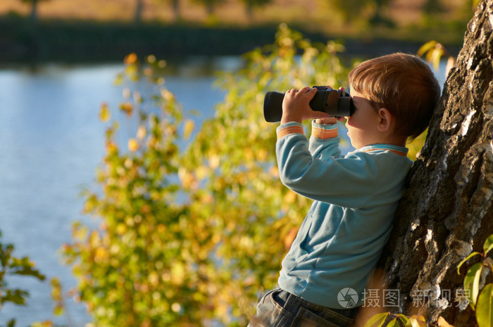 小男孩用望远镜看