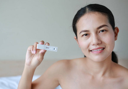 愉快的妇女与正面怀孕显示在测试设备
