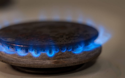 特写镜头从国内厨房灶具的蓝色火焰。燃气灶具燃烧火焰丙烷气
