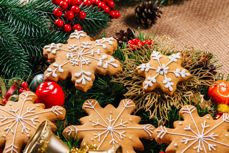 圣诞节姜饼饼干自制与树枝的圣诞树和新年装饰在餐桌上的粗麻布桌布。圣诞快乐明信片