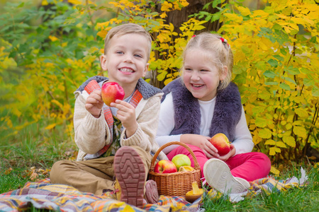 两个快乐的孩子在一个秋天公园野餐
