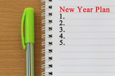 笔记本和钢笔放在木桌和新年计划文本