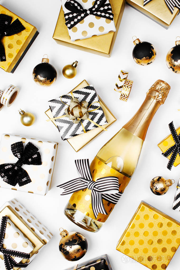 平躺香槟瓶, 礼物和金色包装纸卷在白色背景