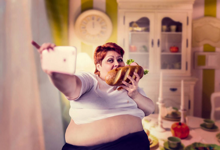 肥胖妇女吃三明治和采取自拍, 不健康的生活方式和肥胖概念