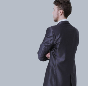 年轻的商业人全身侧查看孤立在灰色背景照片