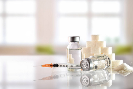 胰岛素小瓶和注射器与背景窗口的白色桌子上