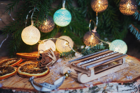 小五颜六色的木制雪橇, 前面的圣诞树枝装饰与照明圣诞球