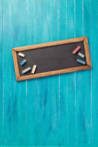 蓝色背景下的黑板和蜡笔