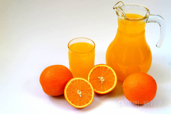 壶和杯桔子汁和成熟的橘子上白色孤立