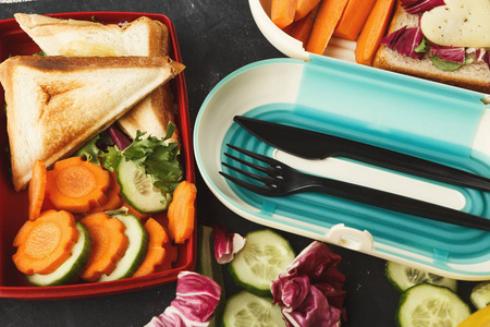带健康食物的午餐盒在黑桌背景