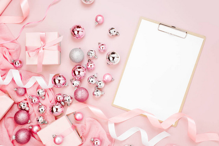 平躺假期背景与空白剪贴板, 圣诞球, 丝带和粉红色的礼物颜色